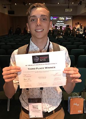 Spencer Halberg holds his certificate